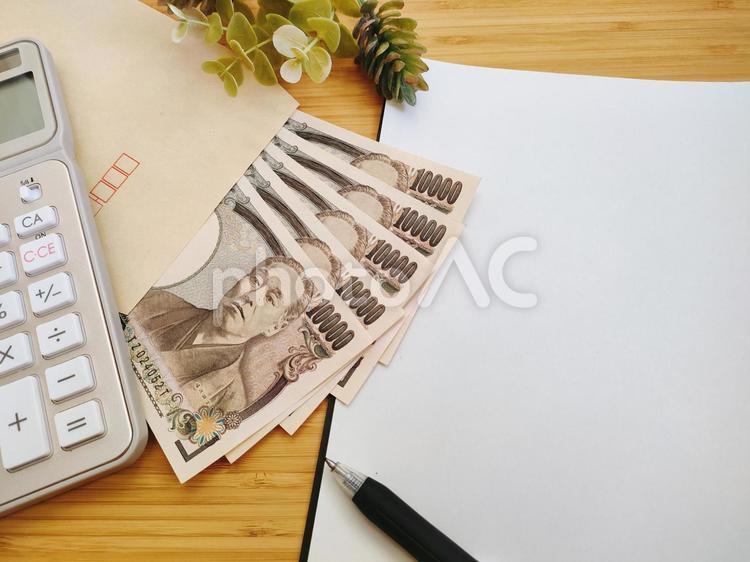机に置かれたお金 お金,一万円,電卓の写真素材