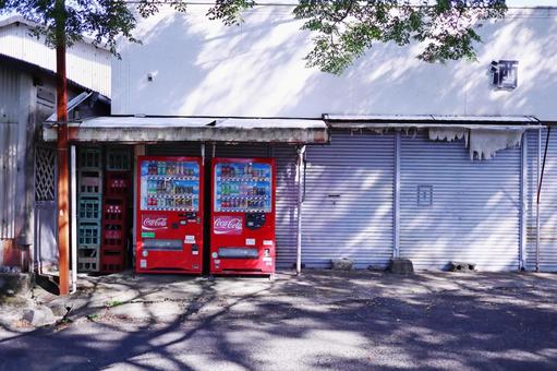 自動販売機と古い酒屋 自動販売機と古い酒屋の写真