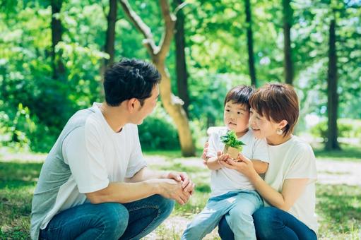 A family with a small potted plant in the woods, sdgs, surroundings, future, JPG