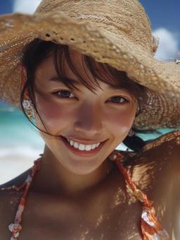 海辺の麦わら帽子を被った女性の写真