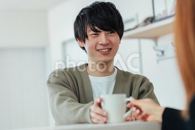 笑顔でマグカップを受け取る男性 男性,笑顔,マグカップの写真素材