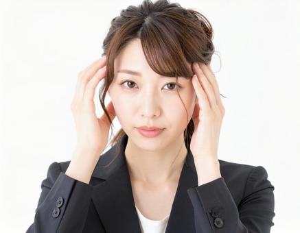頭を抱えて頭痛に悩む女性 頭を抱えて頭痛に悩む女性の写真