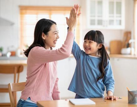 家庭でハイタッチするお母さんと子供 家庭でハイタッチするお母さんと子供の写真