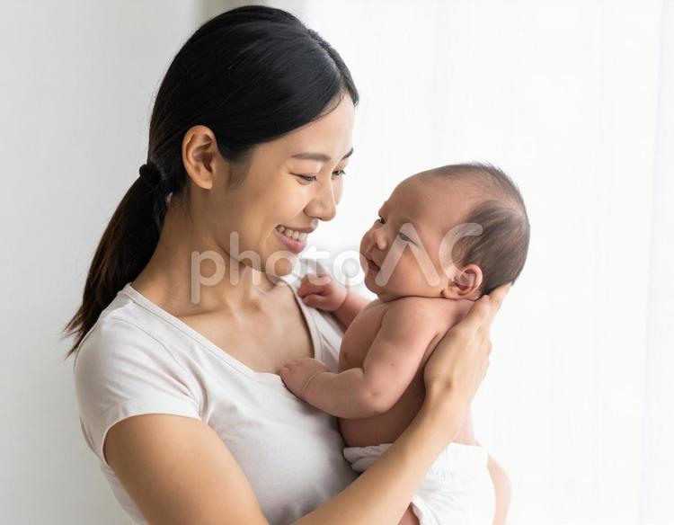 母親に抱かれて安心する赤ちゃんの笑顔 母親,赤ちゃん,新生児の写真素材