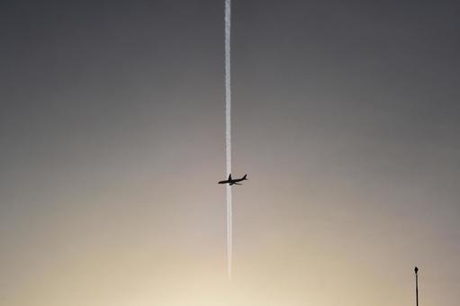 夕焼けの飛行機雲と交差する旅客機 空,晴れ,グラデーションの写真素材