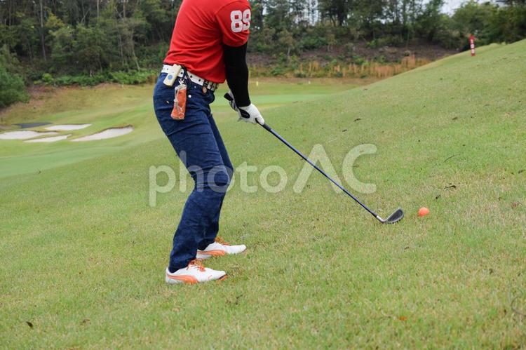 爪先上がりのライからショットを打つ男性 ゴルフ,爪先,爪先上がりの写真素材