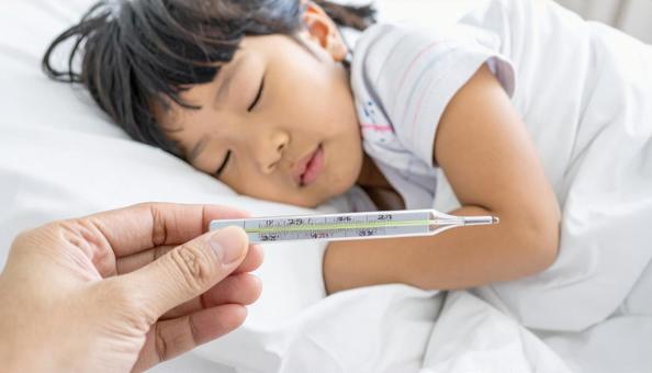 体温計を持つ母親の手と体調不良の子供 体温計を持つ母親の手と体調不良の子供の写真
