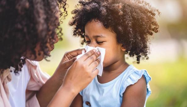 ママに鼻をかんでもらう子供の写真