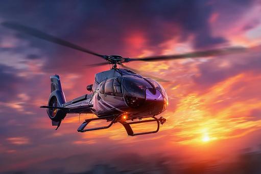 夕焼けの空を飛ぶ最新鋭ヘリコプターの写真