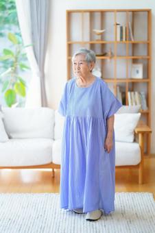 真顔で立っている青いワンピースのおばあちゃん 女性,立つ,穏やかの写真素材