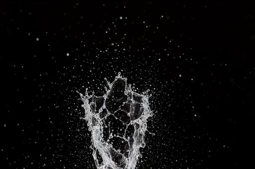 黒背景に水がハネるの写真