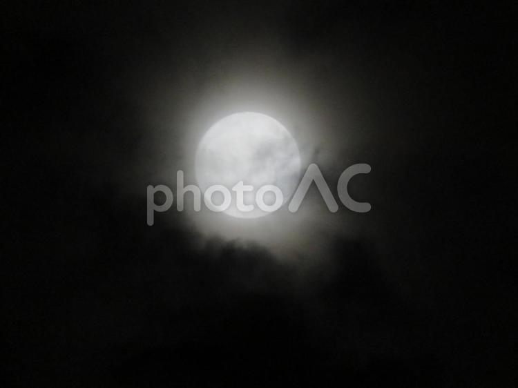 雲に覆われようとしている月 夜空,幻想的,暗闇の写真素材