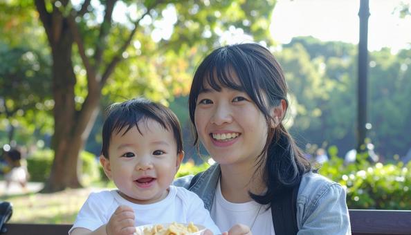 公園でおやつを食べる親子の写真