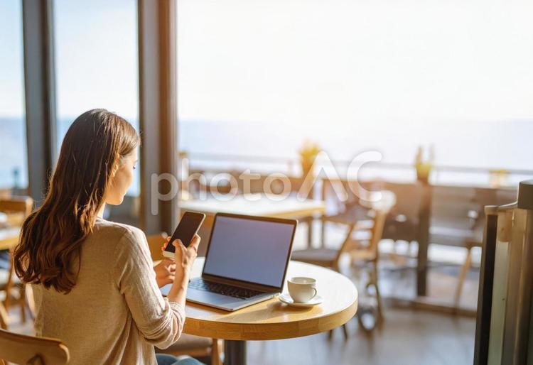 海見えるカフェで作業するフリーランス女性 カフェ,pc,スマホの写真素材