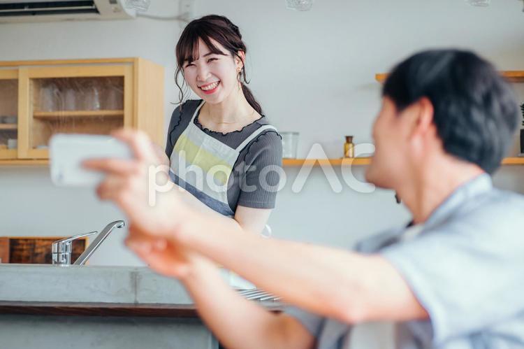 家でくつろぐ仲の良い夫婦（スマホ） スマホ,主婦,アプリの写真素材
