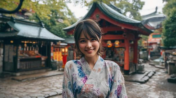 神社の境内にいる浴衣姿の若い女性 神社の境内にいる浴衣姿の若い女性の写真