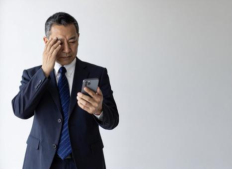スマホ 50代 笑顔 悪い知らせ スマホ 50代 笑顔 悪い知らせ の写真