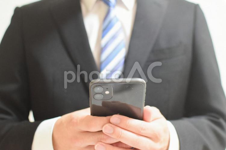 リクルートスーツの男性が携帯操作してる③ スマホ,スマートフォン,iphoneの写真素材
