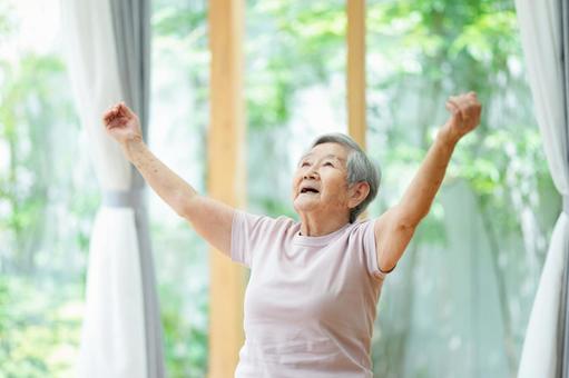 両手を広げ上を見る高齢女性 女性,手をあげる,伸ばすの写真素材