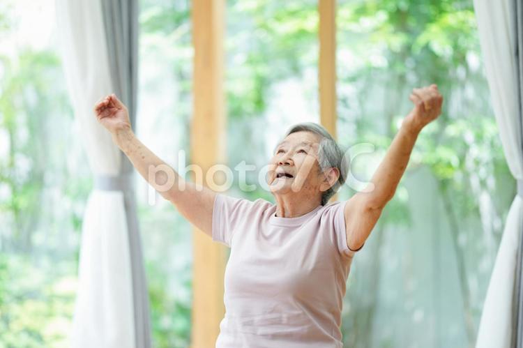 両手を広げ上を見る高齢女性 女性,手をあげる,伸ばすの写真素材