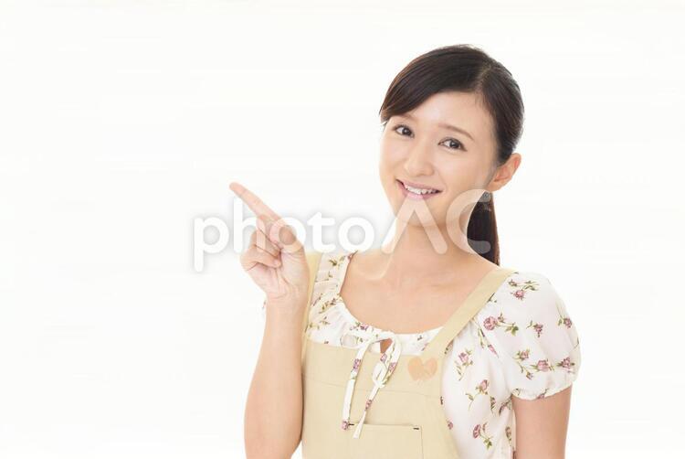 指示する笑顔の女性 女性,女,主婦の写真素材