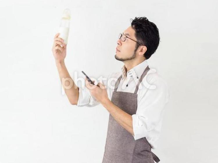 スマホでミルクの作り方を調べる男性のイメージ お父さん,イクメン,イメージの写真素材
