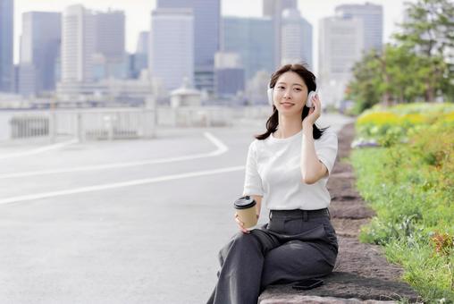 ヘッドフォンで音楽を聴く若い女性 ヘッドフォンで音楽を聴く若い女性 女性,外出,ヘッドフォンの写真素材
