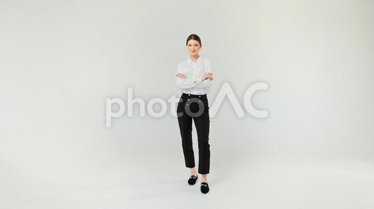腕組みをして立つ白シャツ女性 女性,腕組み,微笑むの写真素材