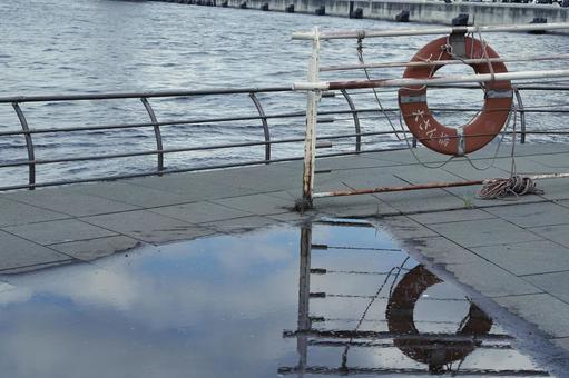 水辺の救命浮輪と水たまりの反射 救命浮輪,浮き輪,水辺の写真素材