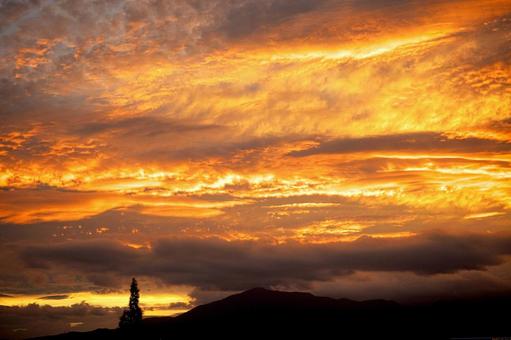 山を覆う燃えるような夕焼け雲 山を覆う燃えるような夕焼け雲の写真