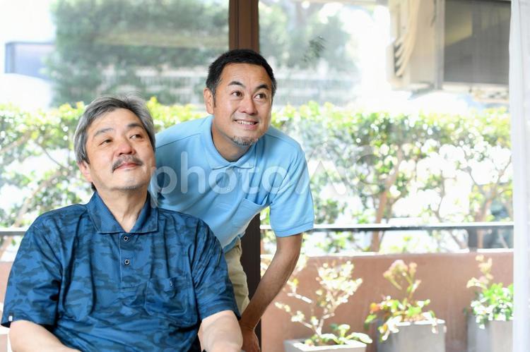 車椅子に乗る高齢者と男性の介護士 高齢者,介護士,男性の写真素材