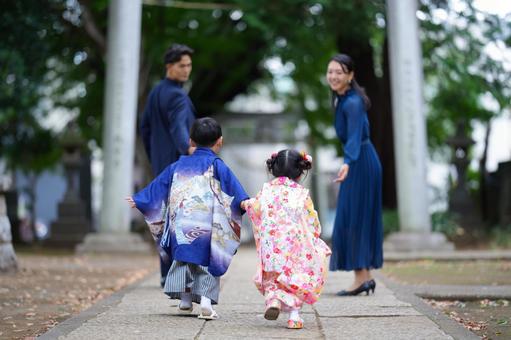 七五三参りで並んで歩く羽織袴と晴れ着の子どもたち 七五三参りで並んで歩く羽織袴と晴れ着の子どもたちの写真