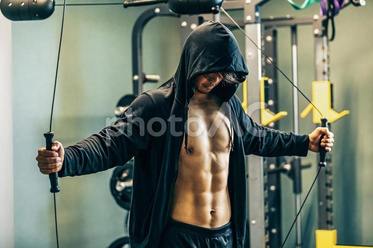 スポーツジムでケーブルマシンを使う男性 ケーブルマシン,スポーツジム,ワークアウトの写真素材
