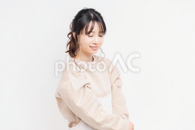 白い背景の前に立ってポーズをとる若い女性 女性,白背景,立つの写真素材
