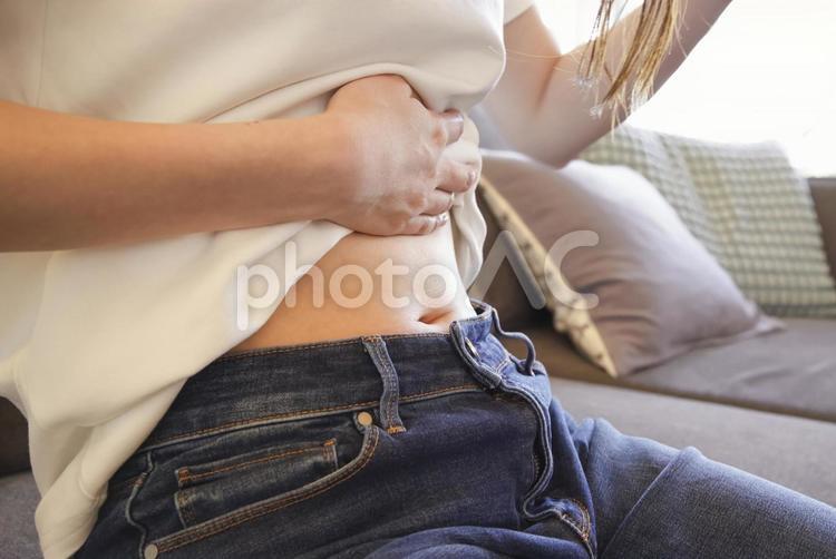 お腹を押さえる女性の腹痛イメージ 腹痛,お腹が痛い,生理痛の写真素材