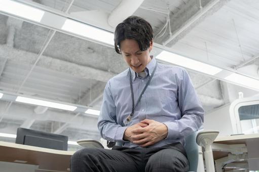体調の悪い若い男性エンジニア 体調の悪い若い男性エンジニア ビジネス,オフィス,腹痛の写真素材
