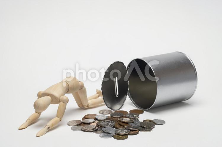 貯金箱からこぼれたコインと落ち込む人形 がっくり,おこずかい,貯金箱の写真素材