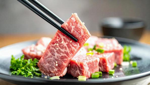 焼肉用の生肉を箸でつまむ 焼肉用の生肉を箸でつまむの写真
