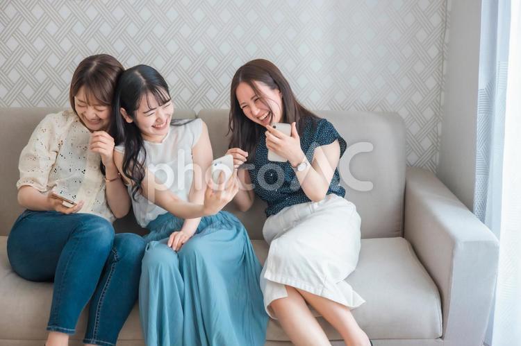スマホを使う女性たち（爆笑・自撮り） スマートフォン,スマホ,女子会の写真素材