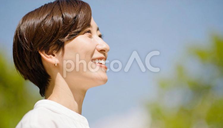 上を向いた日本女性の笑顔の横顔 女性,笑顔,見上げるの写真素材