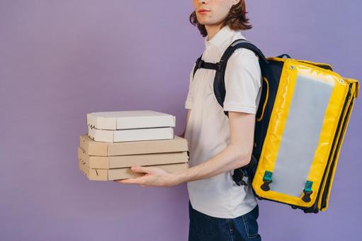 ピザを配達する横向きの男性の写真