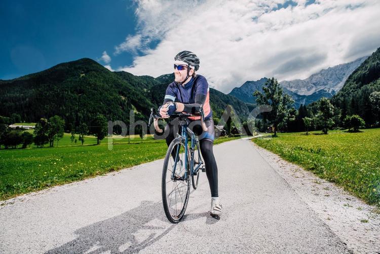 山を背にした自転車乗りの男性39 ツーリング,サイクリング,自転車の写真素材