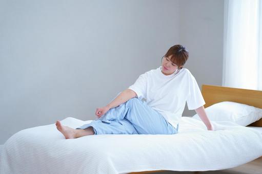 ベッドで足を組みストレッチする女性 女性,ストレッチ,足を組むの写真素材