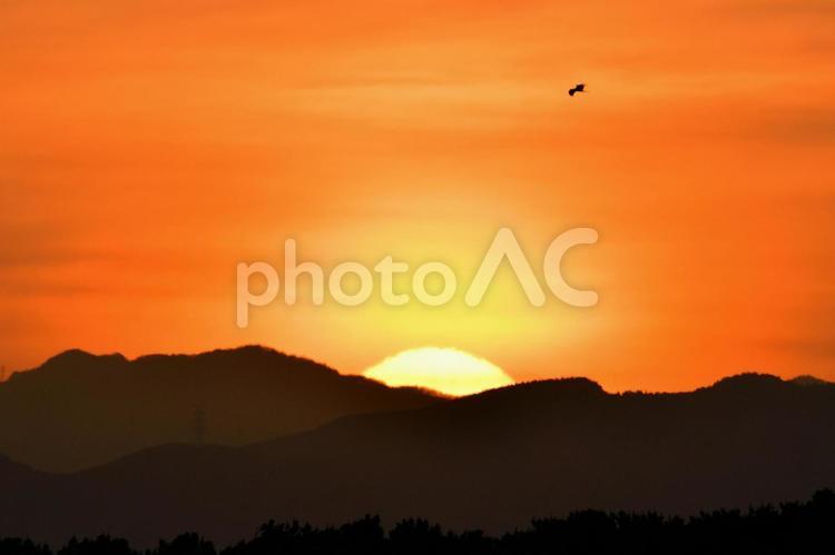 山の向こうへと沈む夕日とカラス 風景,夕焼け,夕暮れの写真素材