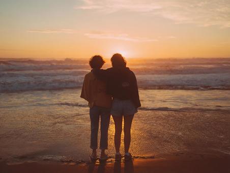 穏やかな夕焼けに包まれた二人のシルエット 穏やかな夕焼けに包まれた二人のシルエットの写真