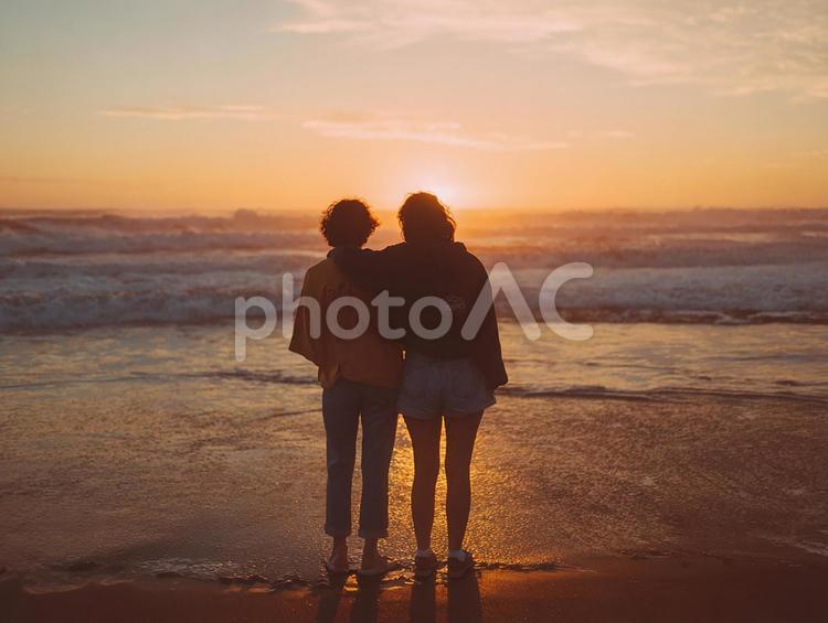 穏やかな夕焼けに包まれた二人のシルエット 友人,友情,女性の写真素材