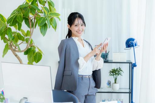 スマホを操作するビジネスウーマン ビジネスウーマン,スマホ,笑顔の写真素材