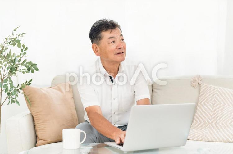 パソコンを使う高齢者男性（笑顔） パソコン,高齢者,ノートパソコンの写真素材