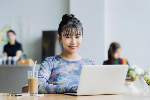 カフェで仕事をするフリーランスの若い女性 カフェで仕事をするフリーランスの若い女性の写真