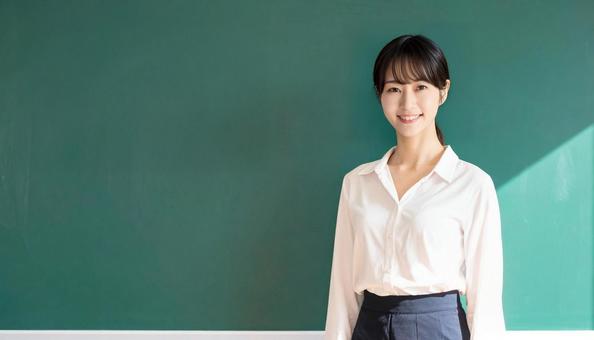 黒板の前に立つ女性教師 黒板の前に立つ女性教師の写真